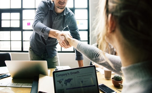 man and woman shaking hands over business growth