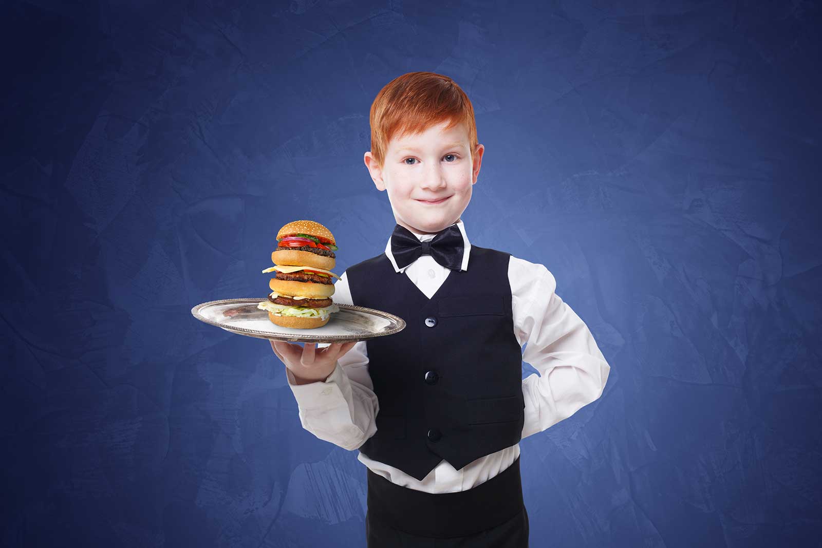 little boy holding a plate with burger