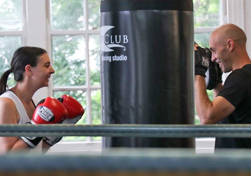 Woman in a gym with a boxing coach