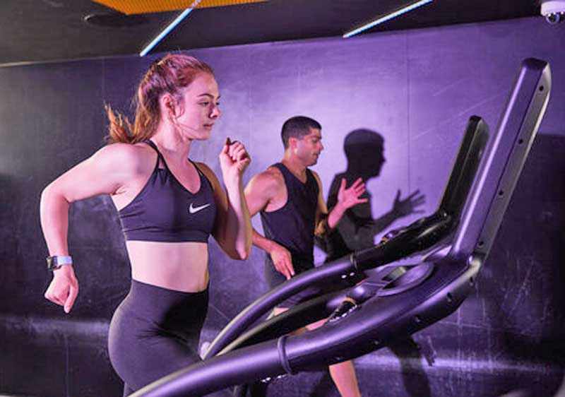 Woman running on a treadmill in a gym.