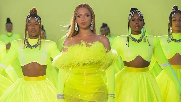 Beyoncé in a yellow costume performing with her backup dancers