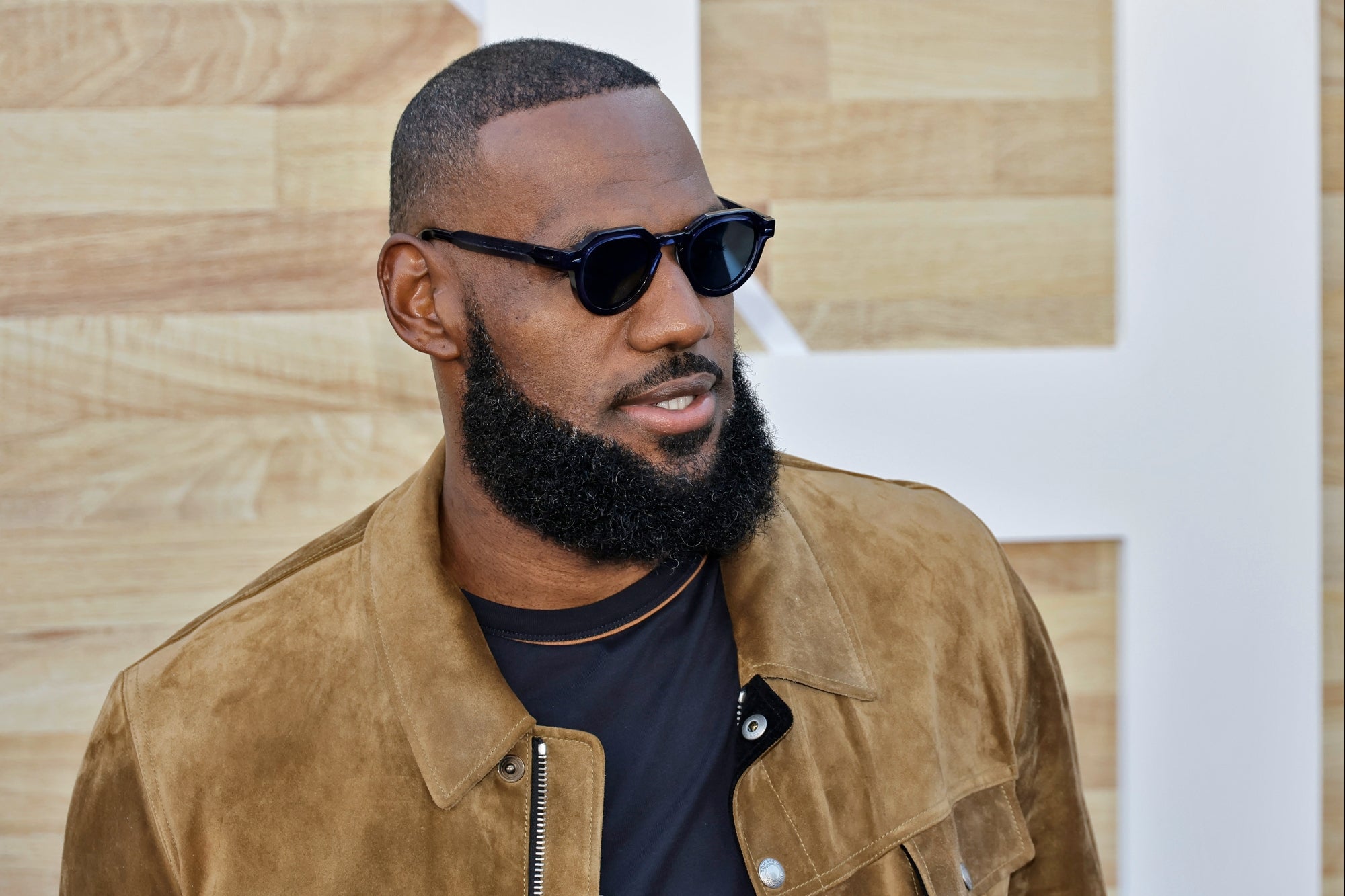 LeBron James in black shades, wearing a brown leather jacket