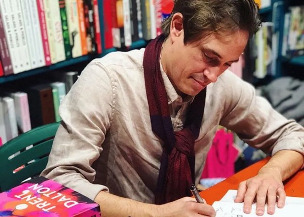 Person writing with a pen in a library