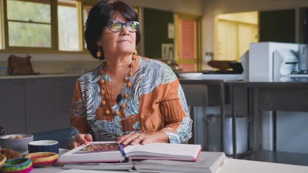 Entrepreneurial woman holding a book and gazing outside in contemplation