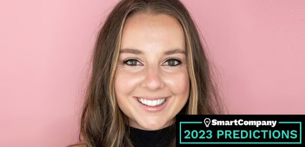 Lottie Dalziel with a bright pink background, wearing a smile