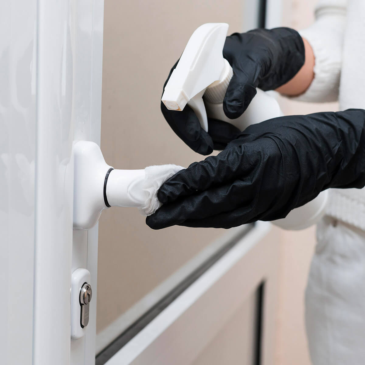 hands-with-gloves-disinfecting-door-handle