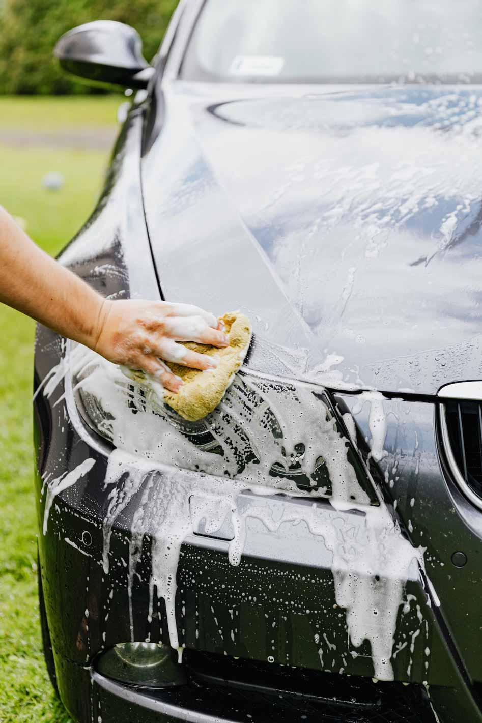 Image of a person washing their black car.